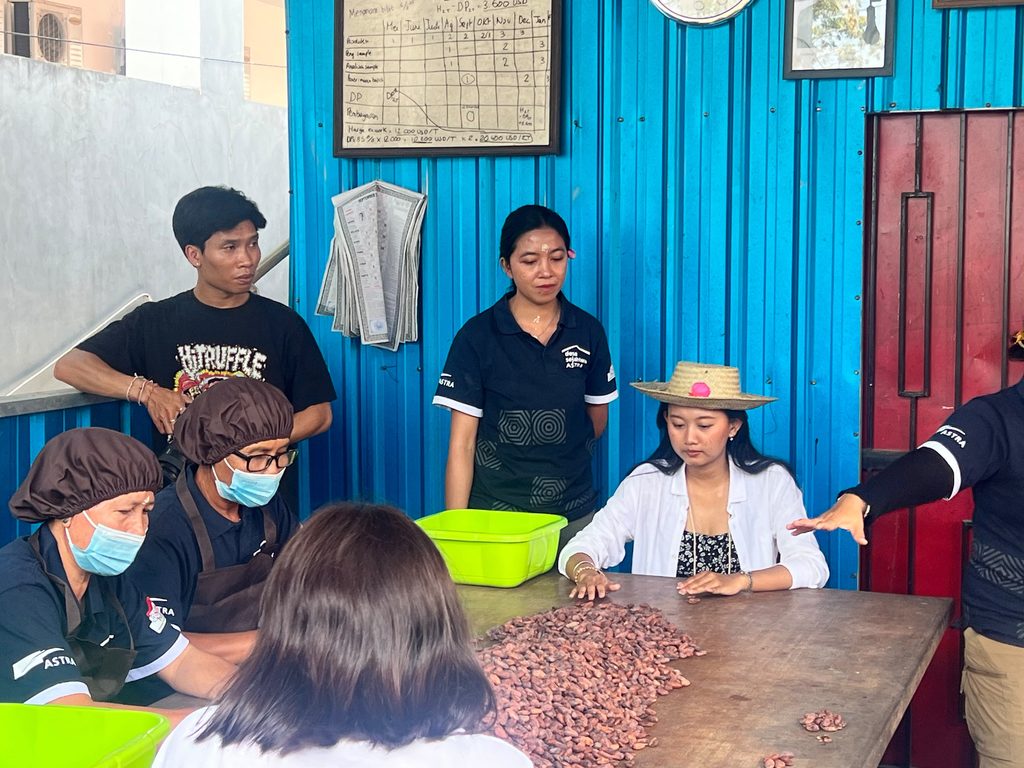Asti Trying Her Hand at Sorting Cocoa Beans during a Visit to Megati Village 